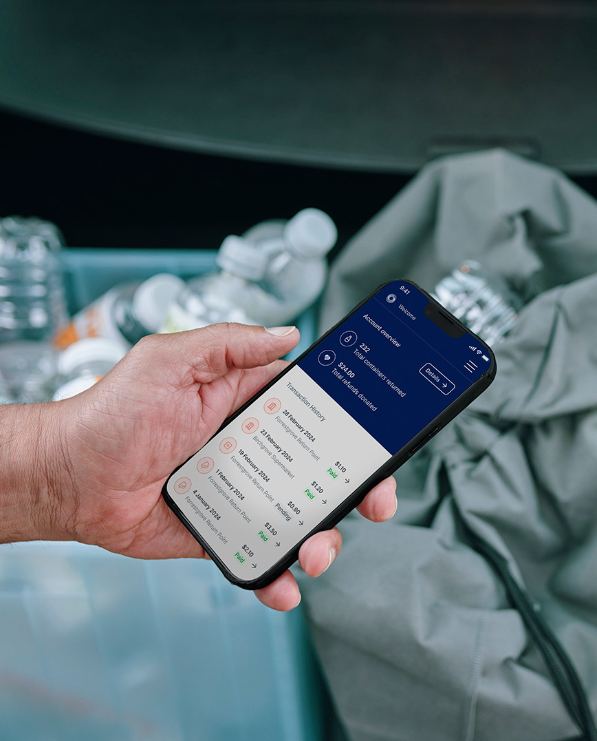 person holding phone with recycling in the background